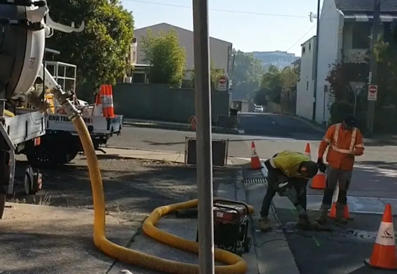 Workers repairing a street with machinery.