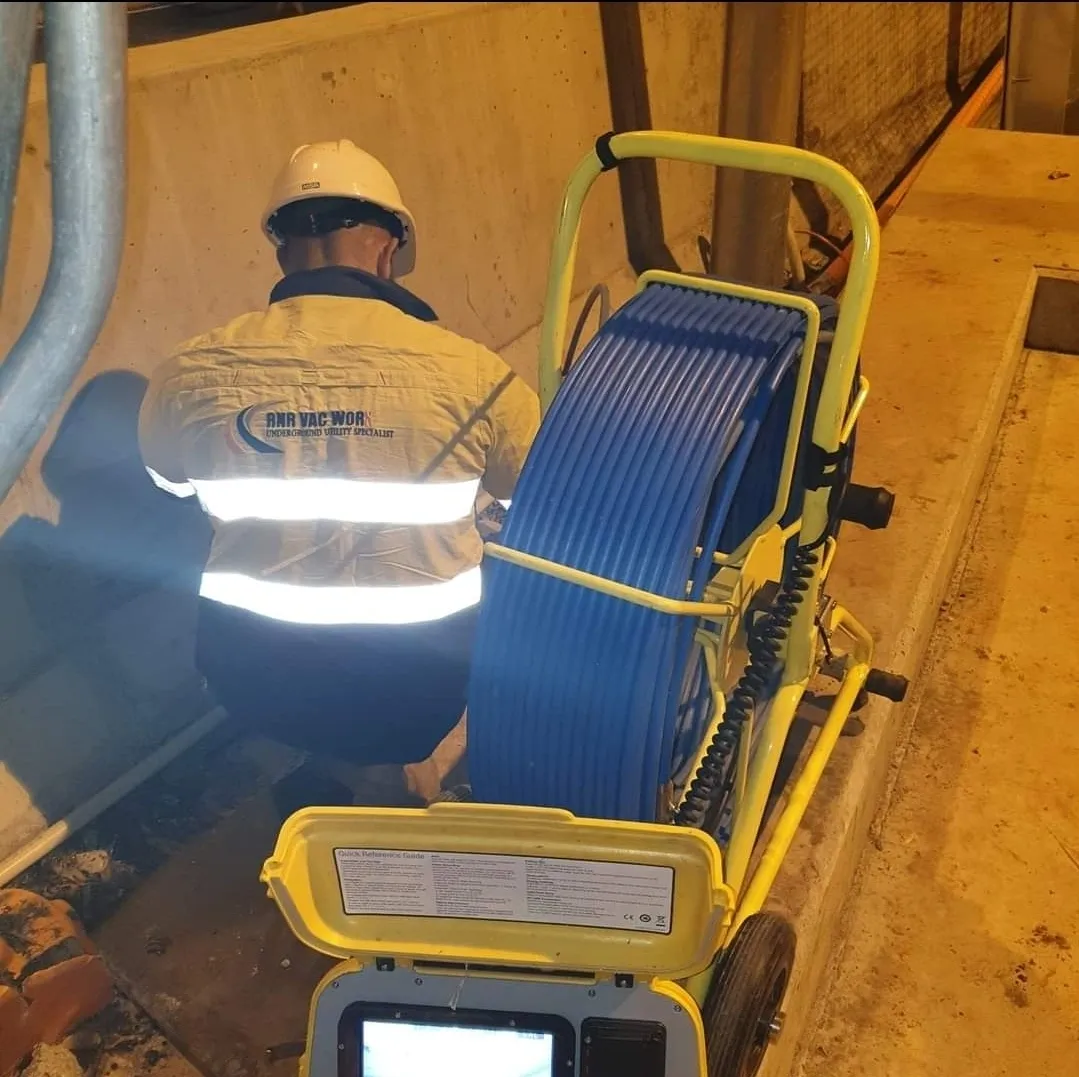 Worker inspecting with blue cable reel.